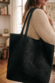 Black woven tote worn on the shoulder