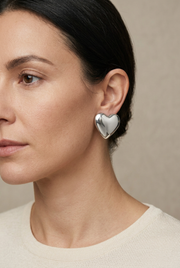 Close-up model wearing silver heart earrings