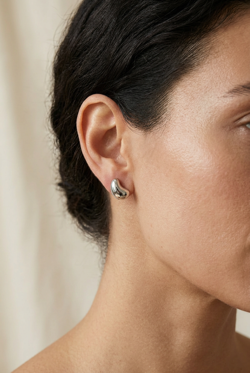 Close-up model wearing the small curved silver stud earrings