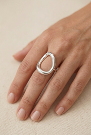 Close-up of a model’s hand wearing the sculptural silver ring