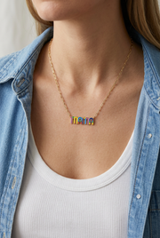 Close-up of a model wearing the colorful mama necklace with a white tank and denim shirt
