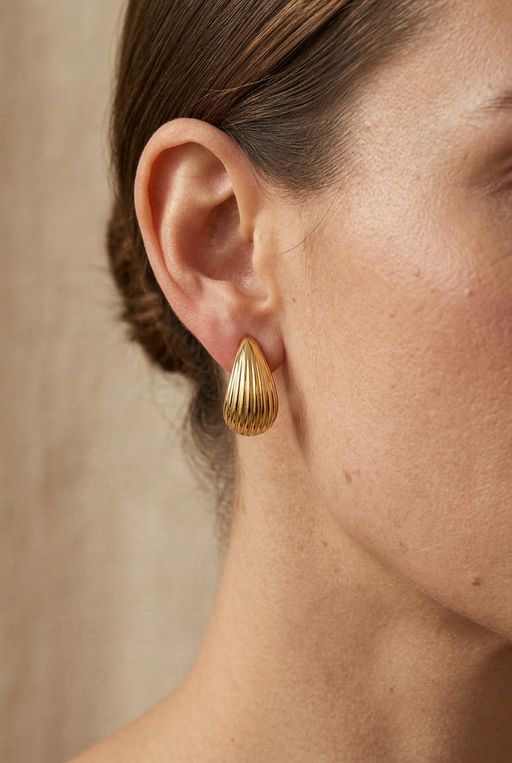 Close-up of a model wearing the gold ribbed earrings
