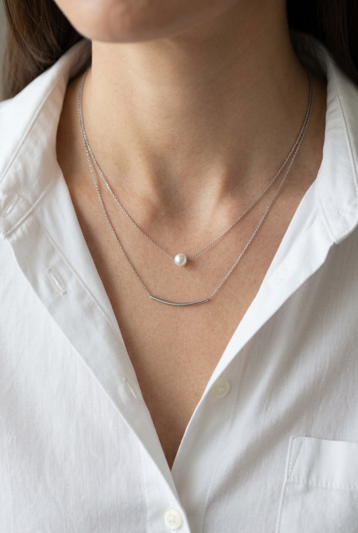 Close-up of the layered necklace on a model wearing a white shirt