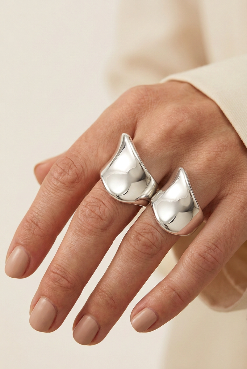 Close-up of the same model wearing two identical silver rings on different fingers