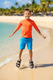 Fun 10-year-old jumping at the beach with black Ateneo sandals