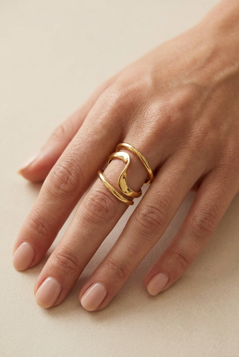 Gold sculptural ring on a hand model