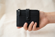 Hand holding the black mini purse