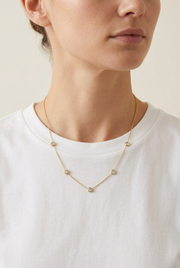 Model wearing the necklace with a white tee