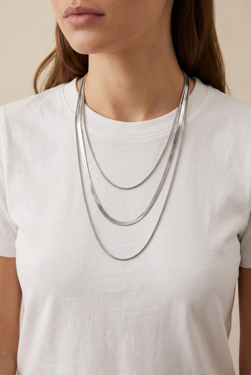 Model wearing the three-layer silver necklace over a white T-shirt