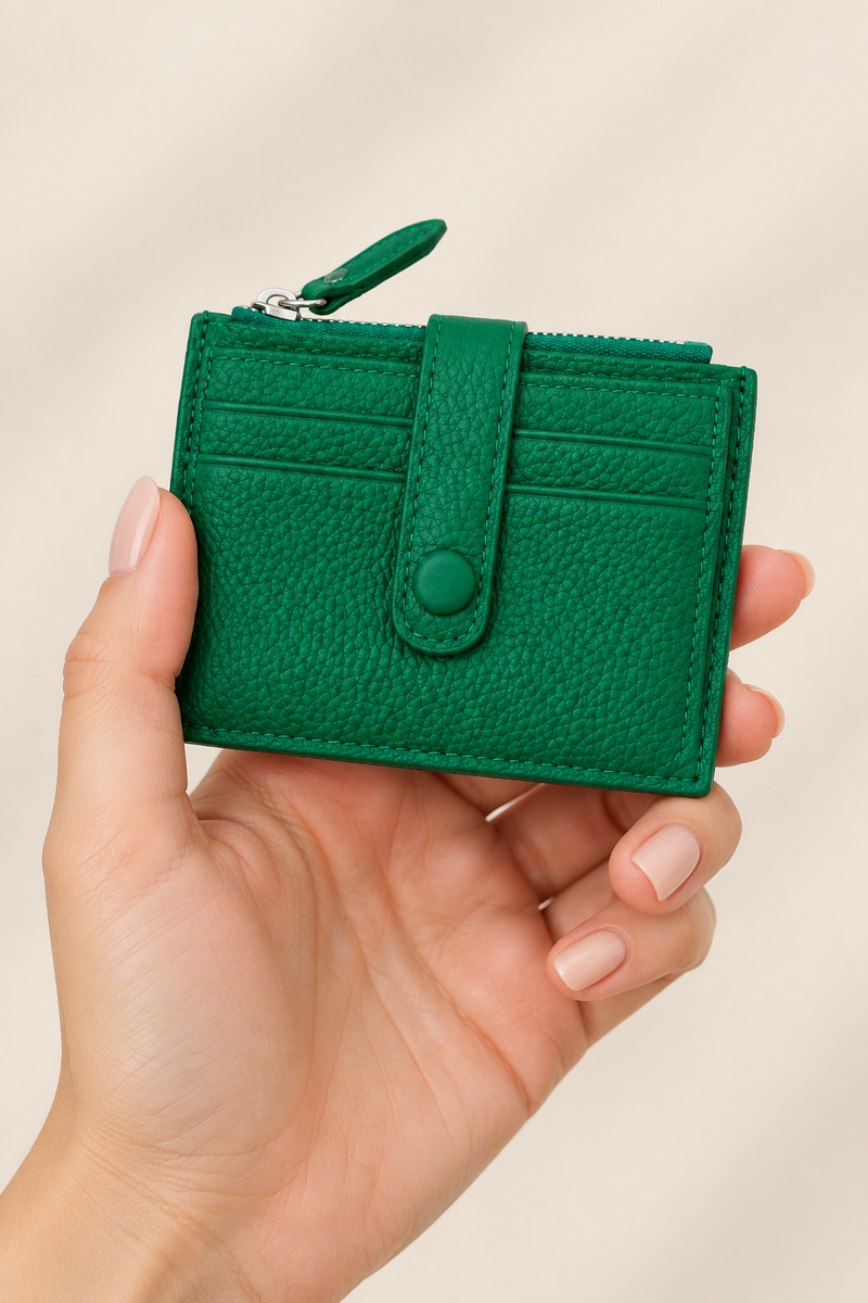 Woman’s hand holding the green mini purse