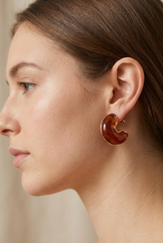 Young adult model wearing the amber crescent earrings in close-up