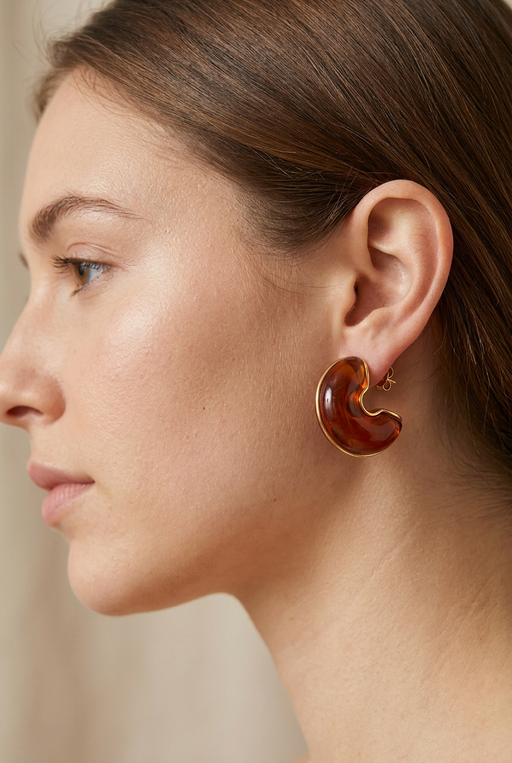 Young adult model wearing the amber crescent earrings in close-up