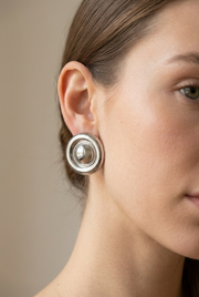 Young adult model wearing the circular silver earrings in close-up