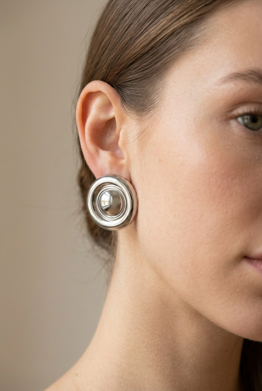 Young adult model wearing the circular silver earrings in close-up