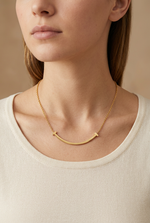 Young adult model wearing the curved gold bar necklace in close-up