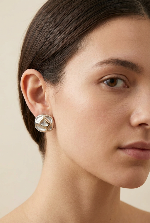 Young adult model wearing the sculpted mixed-metal earrings in close-up