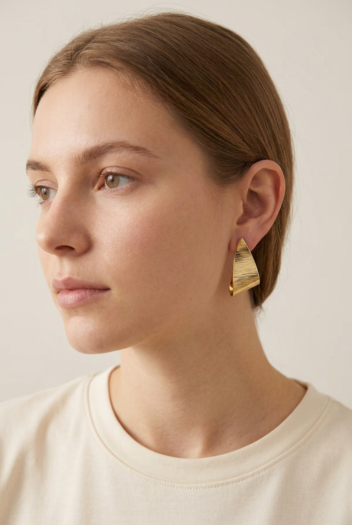 Young adult model wearing the textured gold earrings